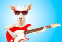 Funny goat in sunglasses with electric guitar on blue background